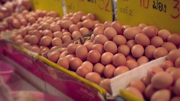 年长的亚洲妇女在农贸市场买鸡蛋
