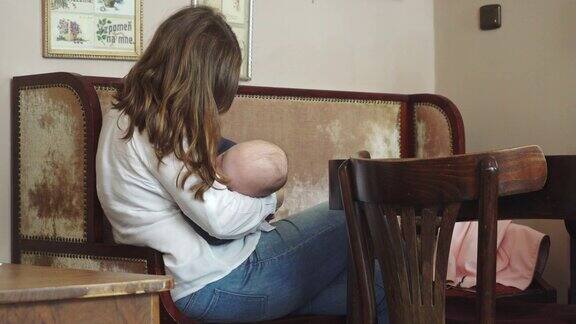 一位妇女在咖啡馆里哺乳她的孩子