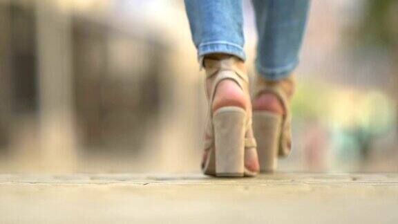 女人双腿穿着时尚高跟鞋走在城市街头都市时尚