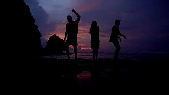 日落在海洋之上朋友们跳舞玩得很开心