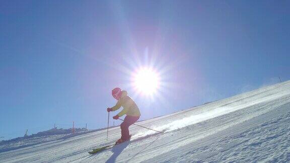 跟踪慢动作滑雪在太阳的耀斑在一个新鲜的早晨整理雪道
