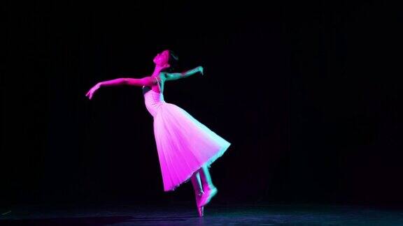 独奏美丽而优雅的芭蕾舞演员在霓虹灯下在黑暗的剧院舞台上跳舞艺术幻想灵活性灵感概念