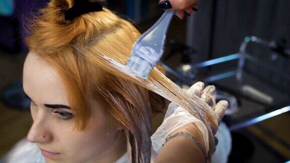 发型师美容工作室将颜料涂在头发上染成金色