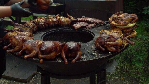 厨师翻转烤鸡架街头美食节上的烤鸡烤鸡烤架上的烤鸡和熏鸡