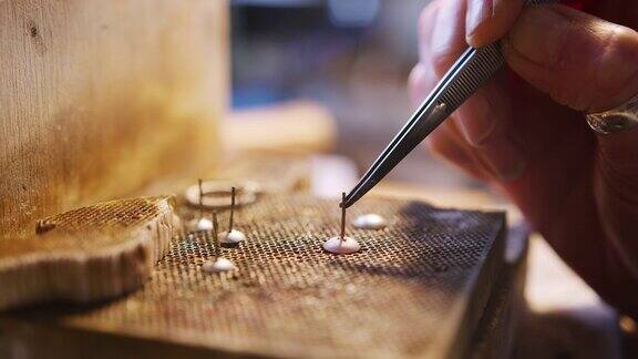 特写的女性珠宝商焊接耳环在工作室