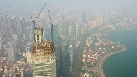 日落时分青岛城市景观市中心摩天大楼建设顶部起重机高空中全景4k中国