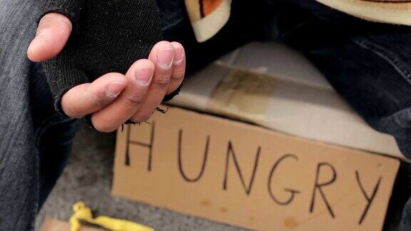无家可归的人伸出颤抖的手乞讨贫穷和痛苦