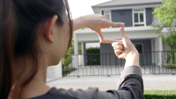 女人的手做着有家庭背景的手势规划未来的居民概念