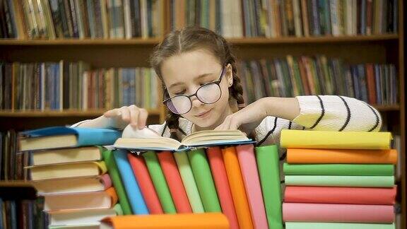 戴眼镜的女孩在图书馆翻阅一本书