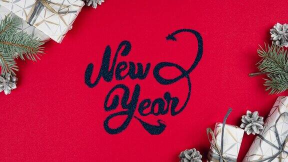 新年的字母出现在红色的背景冷杉树枝银色的球果和周围的礼盒