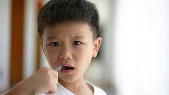 一个亚洲小孩在浴室里刷牙日常健康和牙科护理