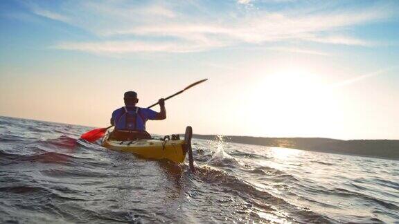SLOMO男子在阳光下乘坐皮划艇在海上经过