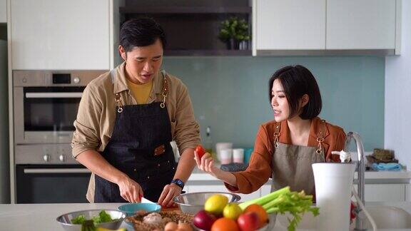 年轻的亚洲夫妇在厨房准备蔬菜