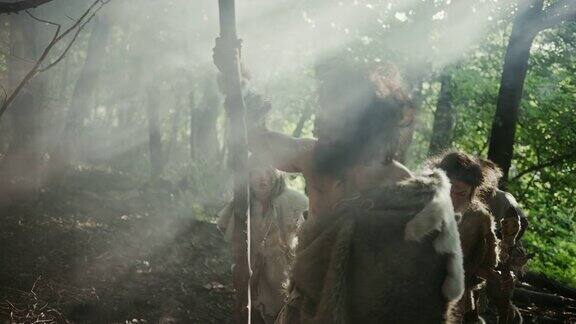部落的狩猎-采集者戴着动物皮拿着石头尖端的工具探索史前森林狩猎动物猎物尼安德特人家庭在丛林中狩猎或为了更好的土地迁徙