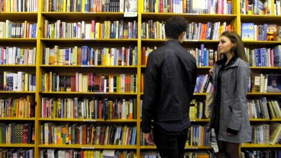 在一家书店里一对可爱的夫妇停下来查看一些书