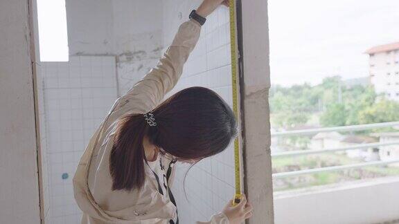 女土木工程师测量建筑内部墙壁的准确性