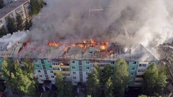 一所住宅的屋顶着火了消防队员正在扑灭高层住宅楼屋顶上的一场火灾