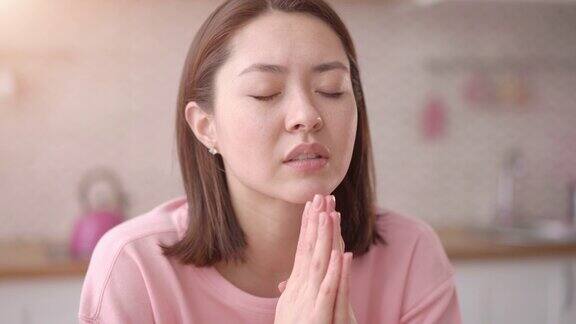 年轻的亚洲女士祈祷与希望牵手紧握在一起