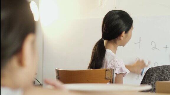 Covid-19期间亚洲女孩在家里用白板教姐姐数学社交距离概念