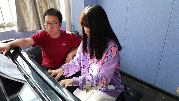 大学老师教女学生学习弹钢琴