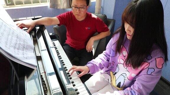 大学老师教女学生学习弹钢琴