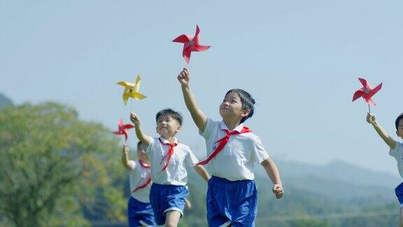 小孩在草地奔跑玩纸风车