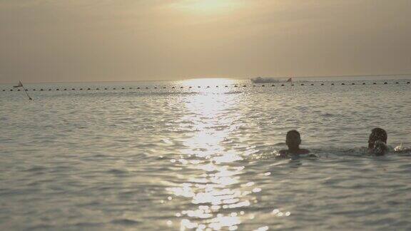 海边夕阳下游泳