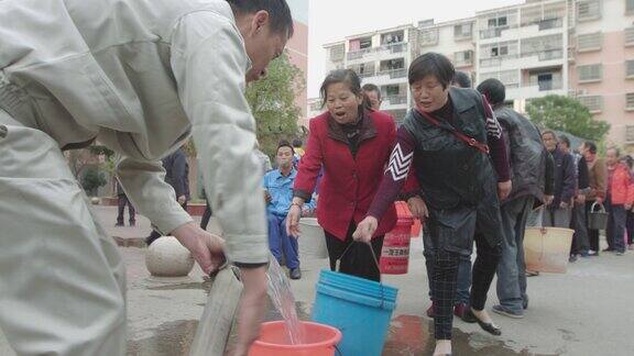 工作人员给居民装水的镜头