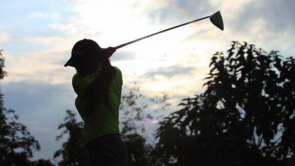 男子背对夕阳打高尔夫