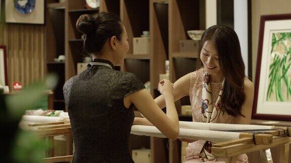中式美女在旗袍店学习刺绣