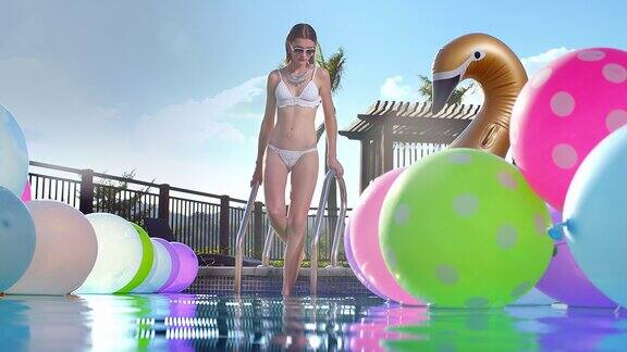 外国美女走进充满气球的游泳池
