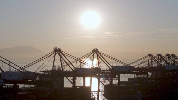 清晨逆光航拍港口码头货轮塔吊装卸集装箱