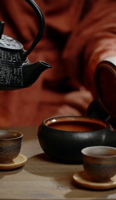 把洗茶的水倒入黑色的茶钵里