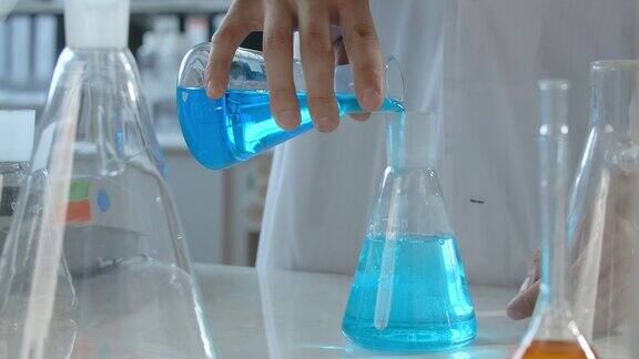 拿起蓝色液体瓶倒入另一个玻璃瓶