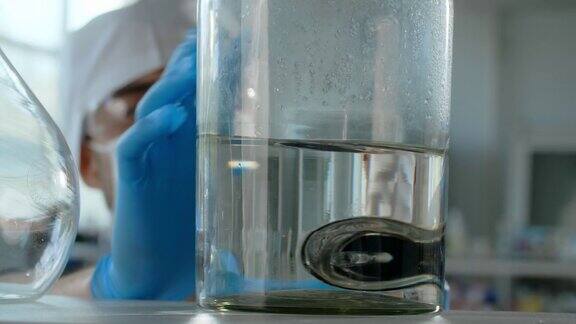 医生工作人移动桌面上装有透明液体的玻璃瓶